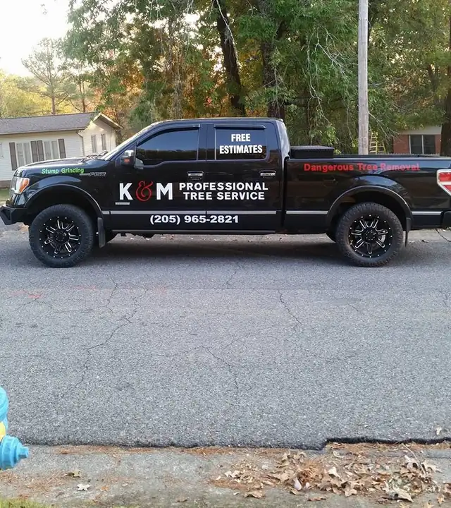 K&M Professional Tree Service pickup lettered with the company phone number and free estimates