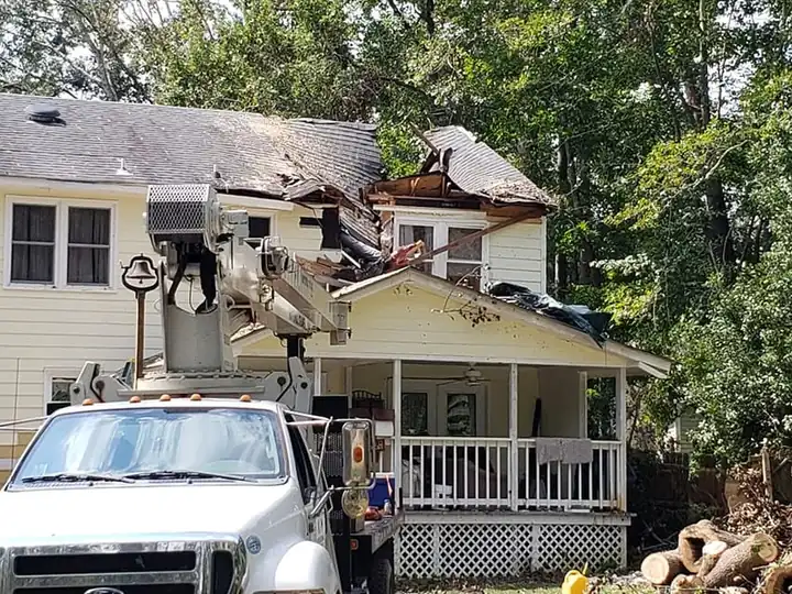 Bucket truck at a storm-damaged home